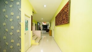 A hallway with a staircase leading to a landing. - KoolKost Syariah near TerasKota BSD (South Tangerang)