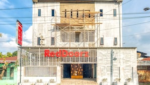 A building with a sign reading "RedDoorz" and a red sign on the left. - RedDoorz @ Jalan Kapten Muslim Medan (Medan)