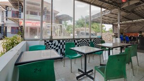 A restaurant with outdoor seating, large windows, and a checkered wall pattern.