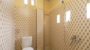 A bathroom with a toilet, shower, and tiled walls. - RedDoorz Syariah near Stasiun Kereta Api Kisaran (West Kisaran)