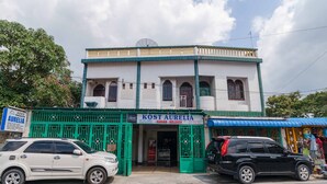 A building with a sign reading "KOST AURELIA" and a green gate. - RedDoorz Syariah near Stasiun Kereta Api Kisaran (West Kisaran)