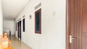 Un pasillo con comedor, puertas de madera y piso de baldosas.