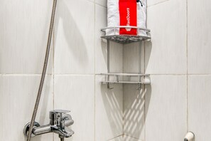 A shower area with a metal showerhead, a handheld showerhead, and a red towel rack. - RedDoorz near Graha Cijantung Mall (Jakarta)