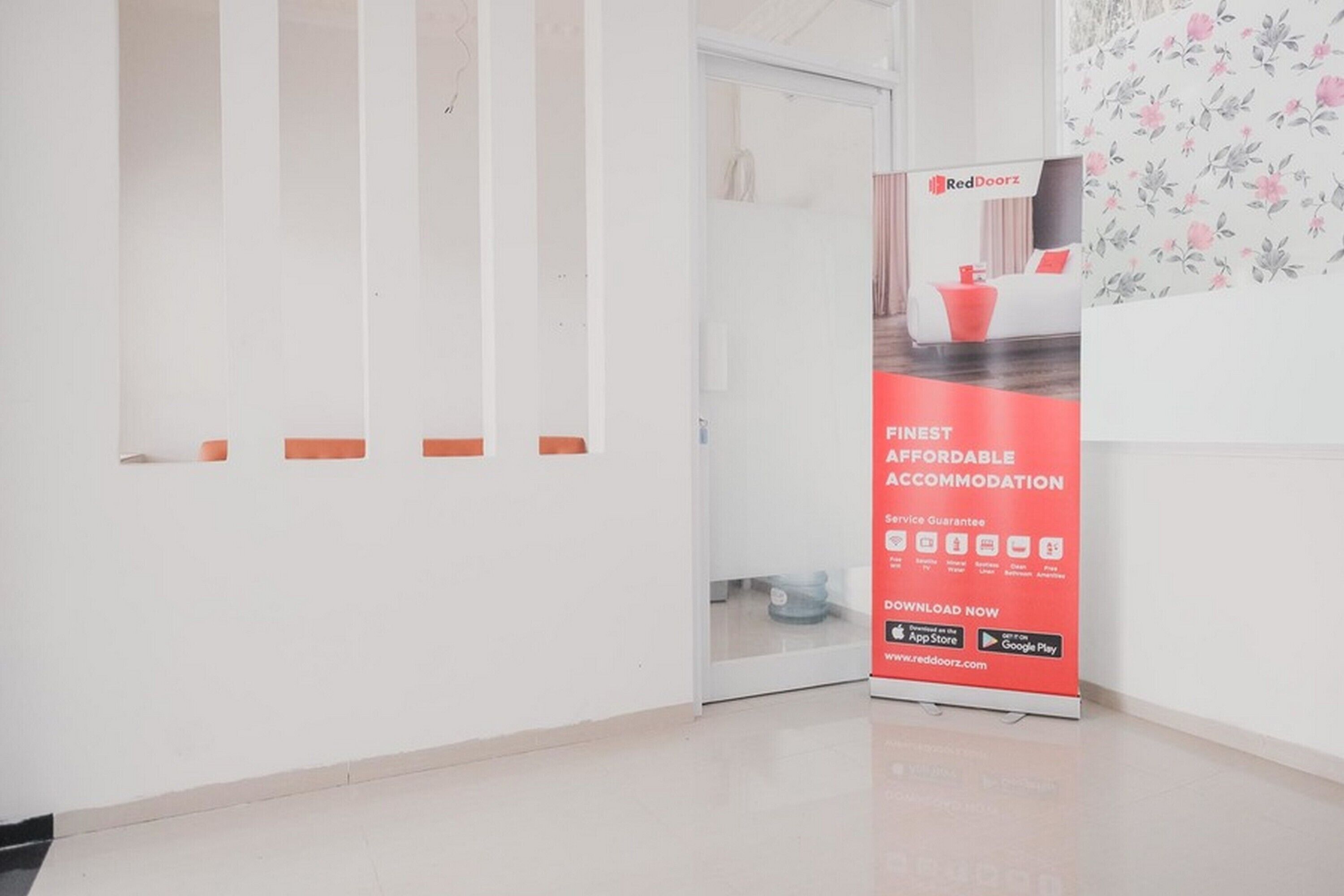 A RedDoorz promotional stand with a message about affordable accommodation and a service guarantee.