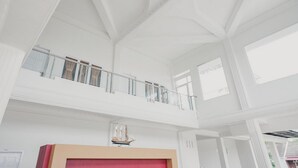 A spacious interior with a high ceiling and a balcony. - RedDoorz Syariah near Arafah Hospital Jambi (Jambi)