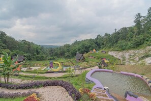 Un jardin aménagé avec un étang, des allées et de petites constructions.
