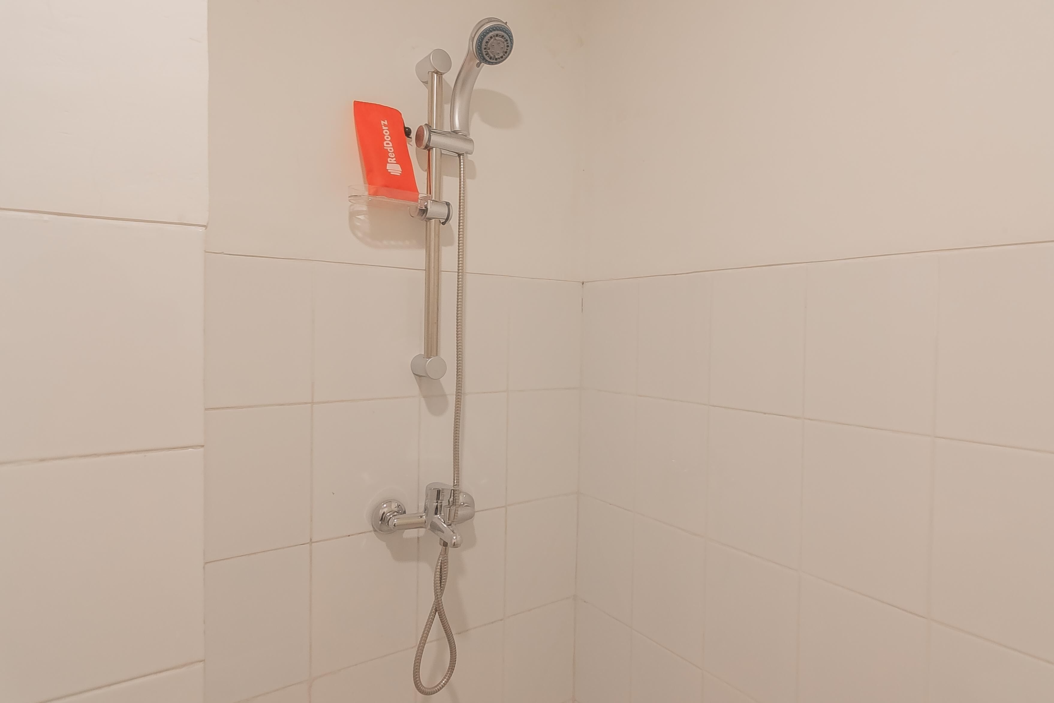 A shower with a handheld showerhead and a handheld shower attachment.