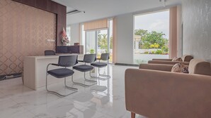 A modern reception area with a reception desk, several chairs, and a sofa.