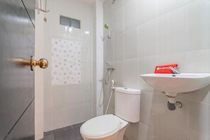 A bathroom with a toilet, a sink, and a shower. - RedDoorz @ Rajawali KM 5 (Palangkaraya)