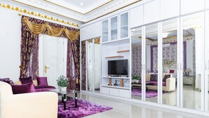 A modern living room with a sofa, TV, and decorative elements. - RedDoorz Premium @ Sea Residence Manado (Manado)