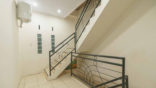 A staircase with a metal railing and a wall-mounted light fixture.
