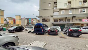 Ein Parkplatz mit mehreren Autos und einem mehrstöckigen Gebäude im Hintergrund.
