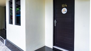 Fachada de un edificio con una puerta negra con el número 104 y un letrero que dice "KOOL KOST".
