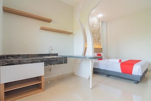 A modern hotel room with a marble bathroom, a glass desk, a bed with a red accent, and a unique wall design.