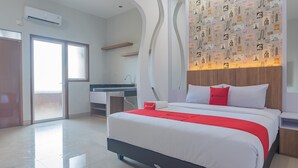 Una habitación de hotel moderna con una cama grande, un escritorio con silla, un lavabo y un armario.