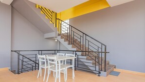 Una escalera con barandilla negra y una pared amarilla decorativa.