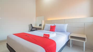 Una habitación de hotel con una cama bien hecha, una mesita de noche y una silla.