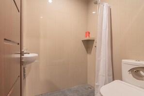 A bathroom with a toilet, sink, shower, and a towel rack.