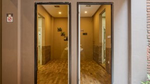 A hotel entrance with a no-smoking sign, a bathroom visible through the glass doors, and a sign indicating the room number. - RedDoorz Hostel near Malang Train Station 3 (Malang)