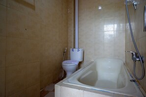A bathroom with a bathtub, toilet, and shower. - RedDoorz near Kendari Beach 2 (Kendari)