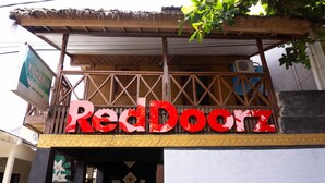 A Red Doorz building with a thatched roof and wooden beams.