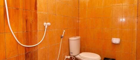 A bathroom with a toilet, a shower, and a trash bin.