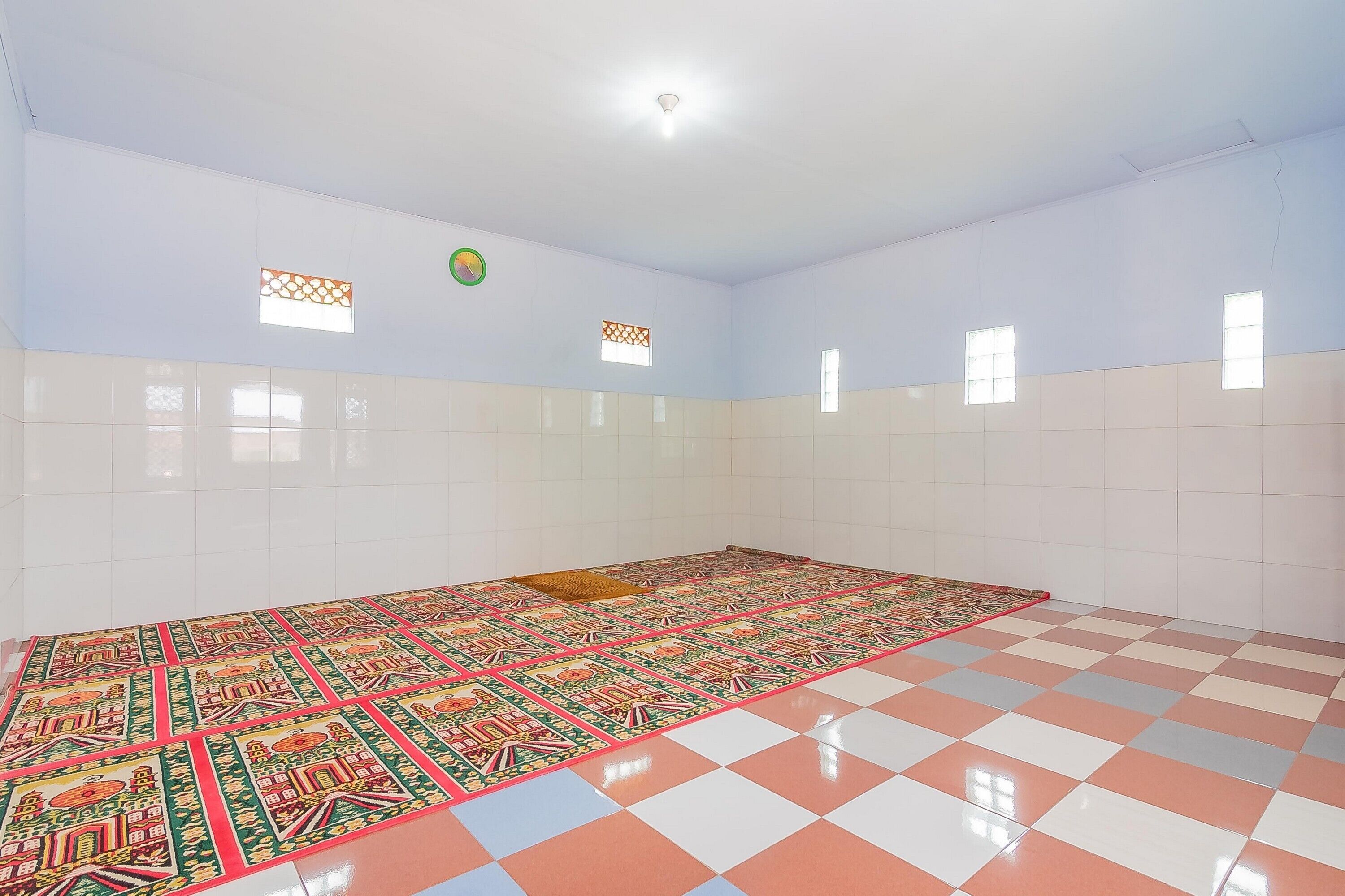 Ein Zimmer mit Schachbrettboden, gefliesten Wänden und einem gemusterten Teppich.