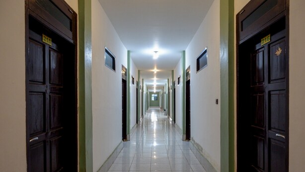 Un pasillo largo y estrecho con puertas a ambos lados, cada una con un número.