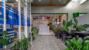 Un pasillo con plantas en macetas, un mostrador de recepción y un cartel que dice 'Hotel Indonesia'.