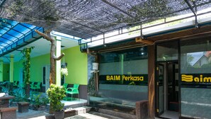 A building with a glass facade and the name "BAIM Perkasa" on the window.