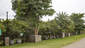 A paved pathway lined with potted plants and a street lamp. - RedDoorz Plus @ Purwodadi (Lawang)