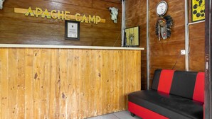 Un comptoir d’accueil en bois sur lequel est apposée une plaque portant l’inscription « APACHE CAMP ».