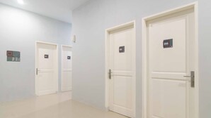 A hallway with three white doors, each marked with a number.