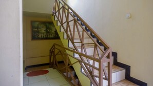 Un escalier avec une rampe en bois et un tableau accroché au mur.
