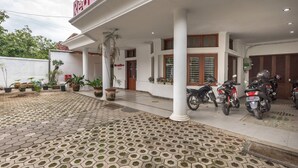 Un bâtiment avec une enseigne indiquant « Red Door » et un espace de stationnement couvert où se trouvent des motos.