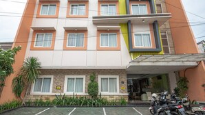 Un immeuble à plusieurs étages avec un espace de stationnement à l’avant.