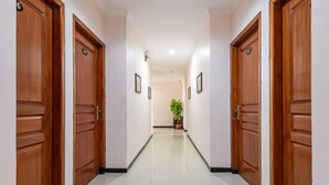 Un couloir avec des portes en bois, numérotées 302 et 303, qui donnent sur une pièce.