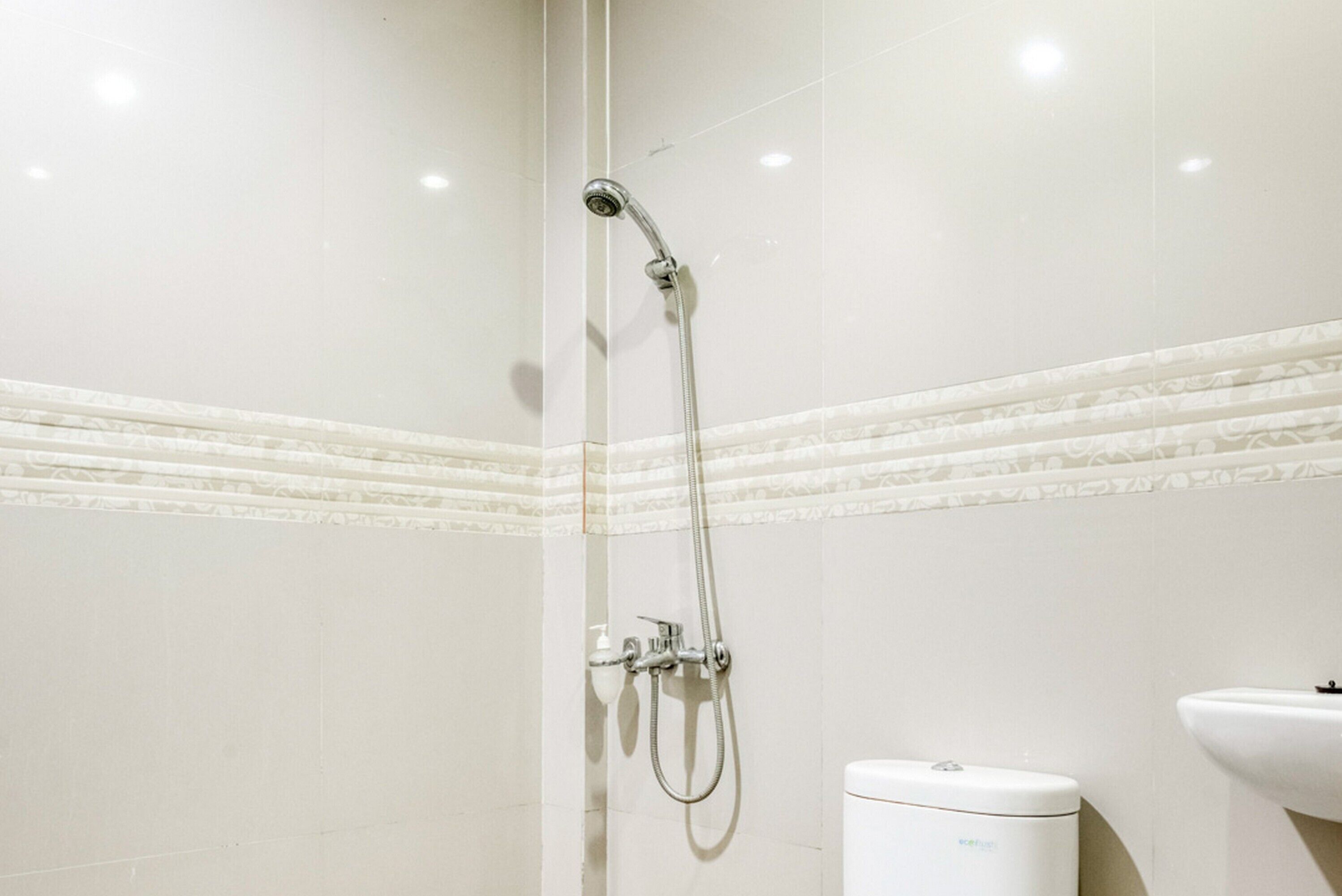 Une salle de bain avec douche, toilettes et lavabo.