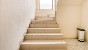 Een trap met beige treden en een prullenbak onderaan.