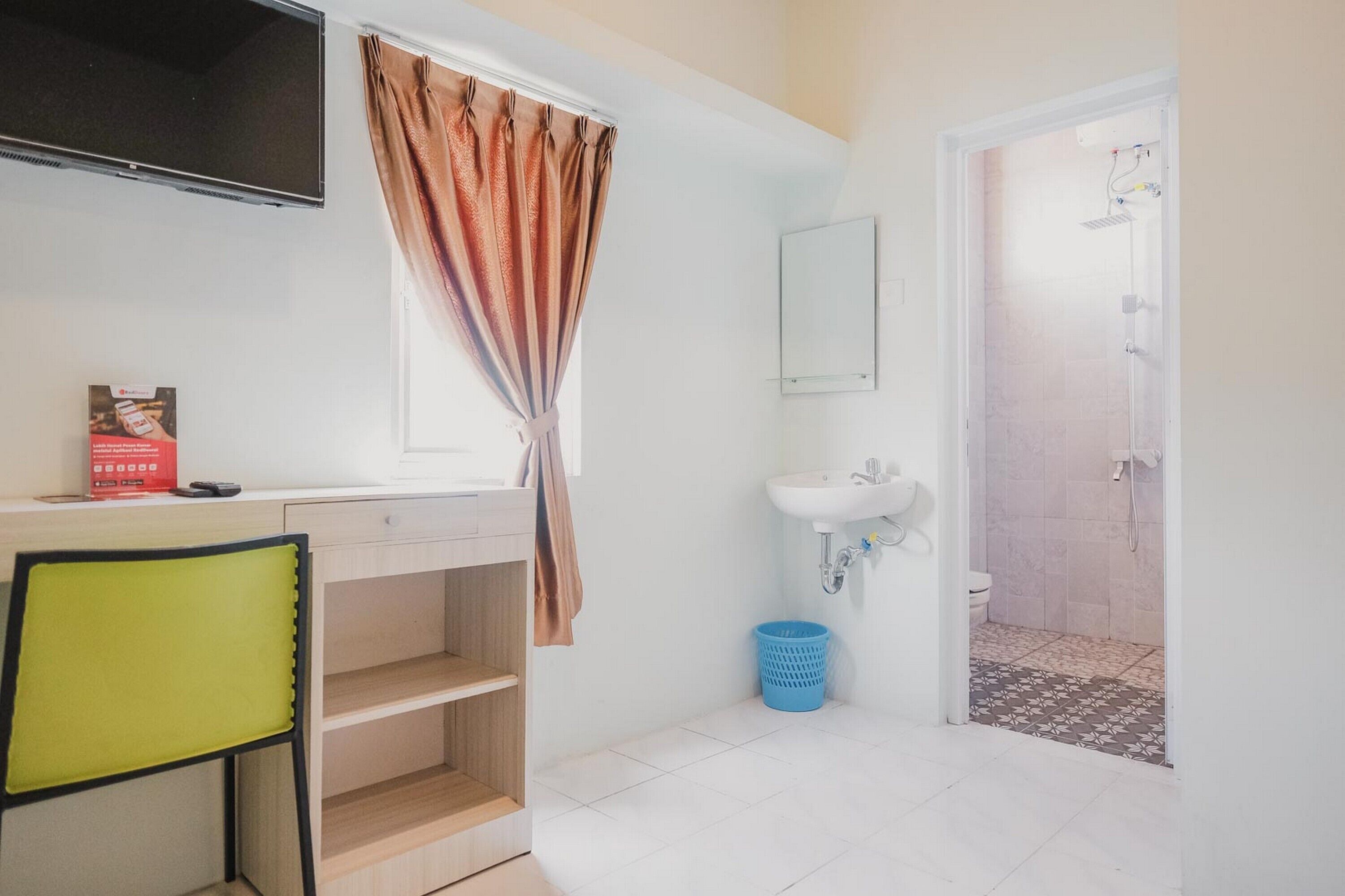 A bathroom with a sink, toilet, shower, and a TV mounted above the sink.
