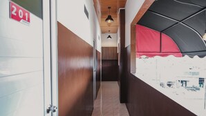 A corridor with lockers, a wooden ceiling, and a red awning. - RedDoorz @ Jalan Pangeran Antasari Lampung 2 (Bandar Lampung)