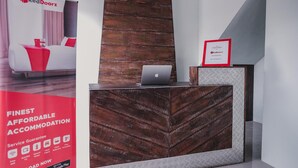 A reception desk with a laptop, a RedDoorz advertisement, and a 'Partner' sign. - RedDoorz @ Jalan Pangeran Antasari Lampung 2 (Bandar Lampung)