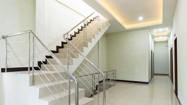 A modern interior with a staircase, polished floors, and recessed lighting. - RedDoorz near Medan Amplas (Medan)