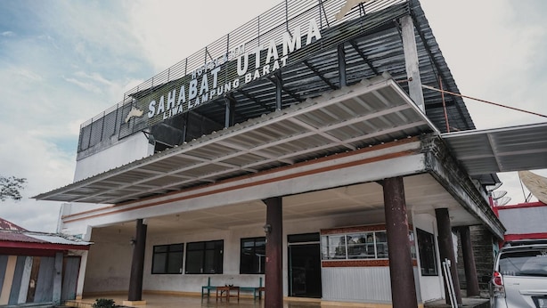 A hotel named "Sahabat Utama" with a covered entrance and a car parked nearby. - RedDoorz Syariah near Kebun Raya Liwa (Gunung Sugih)