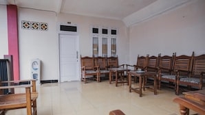 A room with wooden furniture, a white door, and a window with curtains. - RedDoorz Syariah near Kebun Raya Liwa (Gunung Sugih)