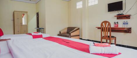 A hotel room with two beds, a TV, a wooden chair, and a shelf with bottled water.