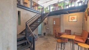 A multi-level interior with a staircase, seating area, and a wall-mounted sink. - RedDoorz near Alun-Alun Garut (Garut)