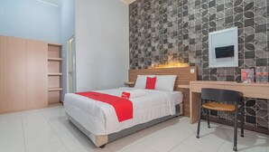 A bedroom with a bed, a desk, and a chair. - RedDoorz near Alun-Alun Garut (Garut)