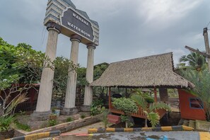 Una torre de agua con columnas y una estructura con tejado de paja.
