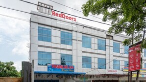 Un edificio con un letrero de RedDoorz, un letrero de PONDOK KELAPA Home Stay y un letrero de JAYA ABADI.
